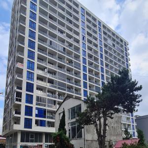 a large apartment building with blue windows at Panoramic #1 Sea Mountain View 1BR apartment Living Room, Balcony, Kitchen in Batumi