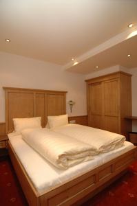 a bedroom with a large white bed with wooden cabinets at Jungmann Apartments in Ischgl