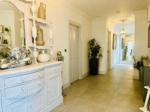 a kitchen with a white dresser and a hallway at Connemara Ocean Escape in Galway