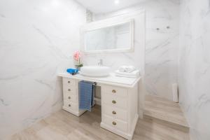 a white bathroom with a sink and a mirror at GELVESTURIST 2 Free parking in Gelves +15 photos