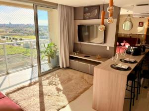 un salon avec une table et une grande fenêtre dans l'établissement Apto aconchegante no DF Plaza, à Brasilia
