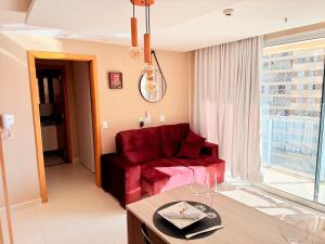 un salon avec un canapé rouge et une table dans l'établissement Apto aconchegante no DF Plaza, à Brasilia 14 autres photos