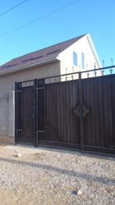 a black gate in front of a house at Частеый дом отдыха in Akchiy