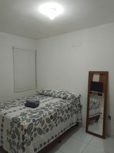 ein Schlafzimmer mit einem Bett und einem Spiegel in der Unterkunft Casa para alugar São João de CG PB in Campina Grande