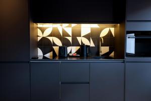 a kitchen with white cabinets and a black counter top at No 5 by Warren Collection in Belfast