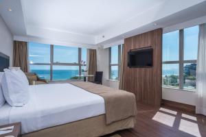 a bedroom with a large bed and a television at Windsor Oceanico Hotel in Rio de Janeiro
