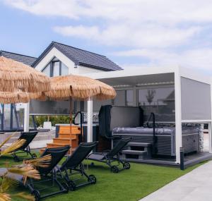- une terrasse avec des chaises, un barbecue et un parasol dans l'établissement APARTAMENTY 3 CÓRKI, à Jastrzębia Góra