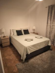 a bedroom with a large white bed with two lamps at appartement avec jardin privé dans une résidence hôtelière haut de gamme in Vilamoura +38 photos