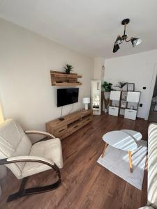 a living room with a couch and a tv at White House Apartments - Boho in Haskovo