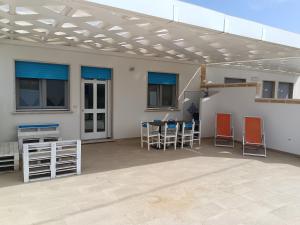 a patio with a table and chairs under a roof at villa,Salentina, vista mare in Marina di Mancaversa