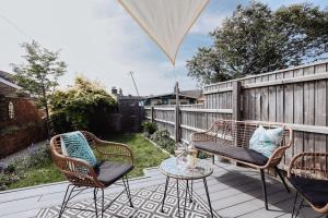 a patio with chairs and a table on a deck at Salterns House - Coastal Escape near Sandbanks in Parkstone