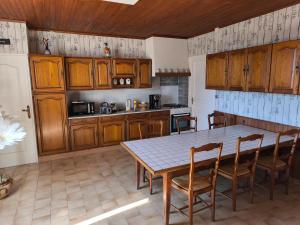a kitchen with wooden cabinets and a table and chairs at Camp'Amis in Viersat