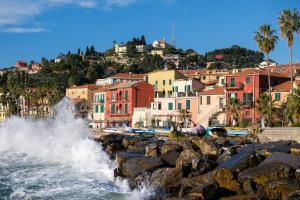 a city with waves crashing on a rocky beach at La sosta del Viandante in Borgomaro