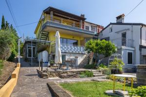 a house with a patio with a table and an umbrella at Borea Strunjan in Portorož