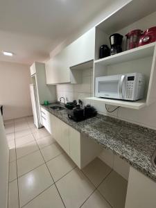 a kitchen with a sink and a microwave at Apartamento Smart in São Carlos