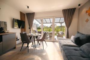 un salon avec un canapé, une table et des chaises dans l'établissement APARTAMENTY 3 CÓRKI, à Jastrzębia Góra