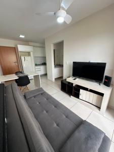 a living room with a couch and a flat screen tv at Apartamento Smart in São Carlos