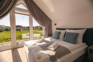un grand lit dans une chambre avec une grande fenêtre dans l'établissement APARTAMENTY 3 CÓRKI, à Jastrzębia Góra 34 autres photos