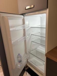 an empty refrigerator with a bottle of water in it at Smart Home Caltanissetta in Caltanissetta +39 photos