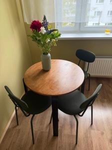 a table with a vase of flowers on it at Mugav rõduga kodu Rapla linnas koos tasuta WiFi, TV & parkimisega ootab Sind! in Rapla +3 photos