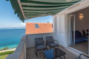 a balcony with chairs and a view of the ocean at APARTMENTS BRUNO 3 - two-room penthouse apartment - wonderful view of the sea - the best location, first row to the beach - 10 minutes from Supetar ferry port - free secured parking - facilities nearby in Sutivan