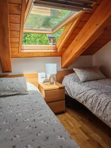 a attic bedroom with two beds and a window at Apartamento abuhardillado y espacioso Aüt 3 in Pla de l'Ermita