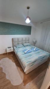 a bedroom with a bed with a blue comforter at Darius in Tuzla
