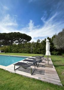 a table and an umbrella next to a pool at Villa Bacchus Ramatuelle, piscine, plage 800m! in Saint-Tropez