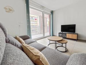 a living room with a couch and a table at Lumineux, terrasse cosy et parking privé inclus in Metz