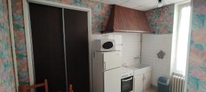 a small kitchen with a refrigerator and a microwave at Villa Mon Repos 2 in La Bourboule