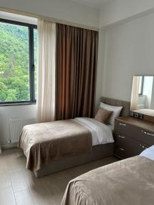 a bedroom with two beds and a large window at Level 8 Dilijan in Dilijan
