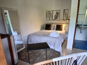 a small room with a bed and a sink at Itamambuca Casa de Praia in Ubatuba