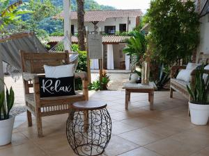 a patio with chairs and a table with a sign on it at Itamambuca Casa de Praia in Ubatuba +9 photos
