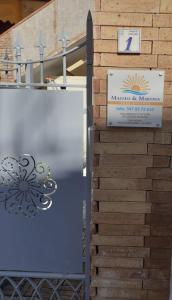 a gate with a sign next to a building at Mazzeo in Santa Maria di Castellabate