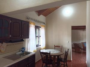 a kitchen with a table and chairs and a sink at Cabaña la candela in Bernal