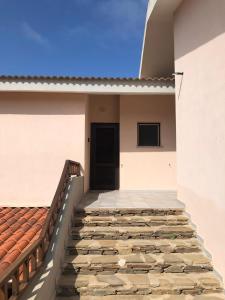 a stairway leading up to a building with a door at CASA STINTINO tra Ginepri e Mare in Stintino