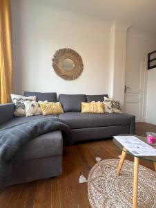 a living room with a blue couch and a mirror at PARIS-MONTROUGE Magnifique Studio Appartement de 35m2 - très cosy pour 1 à 6 personnes refait à neuf - ENTIRE APARTMENT LUXIRIOUS AND WARM - Montrouge Paris 14ème - Proche Aéroport Orly & Parc Expositions Porte de Versailles FREE WIFI GRATUIT in Montrouge +81 photos