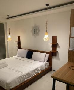 努沙杜瓦3 BR Chrysanthemum Villa nusadua的一间卧室配有白色床单和灯。