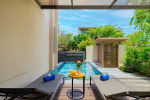 a swimming pool with a table next to a house at Ocean sand villa in Cam Lâm