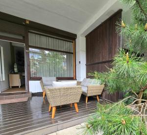 eine Terrasse mit einem Sofa und Stühlen auf einer Terrasse in der Unterkunft Haustory Palanga Apartment in Palanga