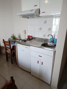 a kitchen with white cabinets and a sink at Irida Studios in Agios Ioannis Pelio +65 photos
