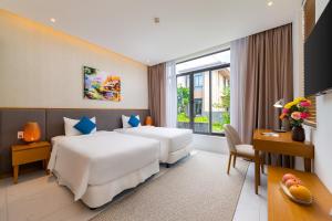 a hotel room with two beds and a desk at Ocean sand villa in Cam Lâm +19 photos