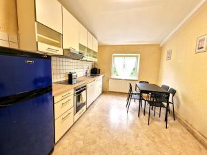 KürtenにあるVS- Kürten Comfort Apartmentのテーブルと椅子と冷蔵庫のあるキッチン