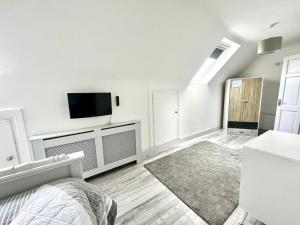 a white living room with a flat screen tv at Connemara Ocean Escape in Galway