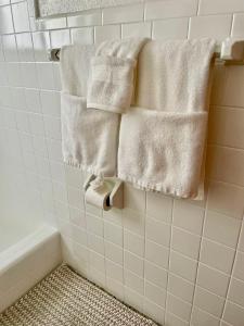a bathroom with white towels hanging on a wall at Renew Apart - Our Home Pompano in Pompano Beach +32 photos