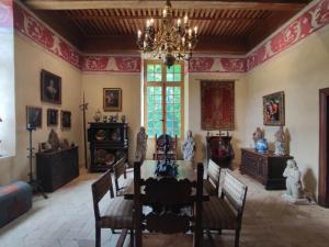 a dining room with a table and a chandelier at Château de Crépol in Crépol