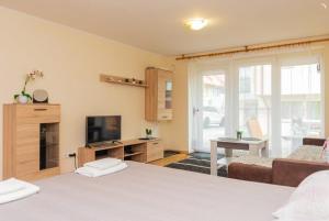 a room with a bed and a tv and a couch at Kotedzas in Nida