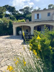 a white house with yellow flowers in front of it at Le Fagneton - Seaview Villa Cote d'Azur in Roquebrune-sur-Argens