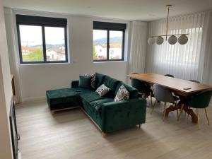 a living room with a green couch and a table at Casa das Eiras, em Cinfães, no Douro in Cinfães