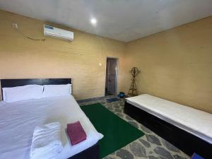 a bedroom with two beds and a camera at Fish O Farm Guest House in Jhawāni +78 photos